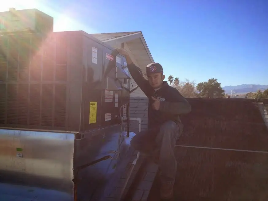 HVAC technician performing Heat Pump Repair on a rooftop unit in Edwardsville